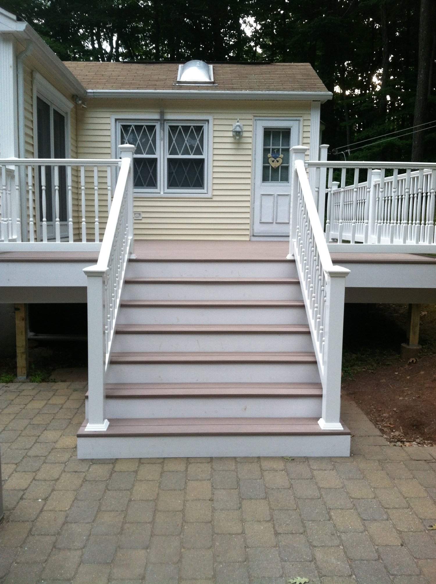 A newly built deck with a clean white railing and stairs