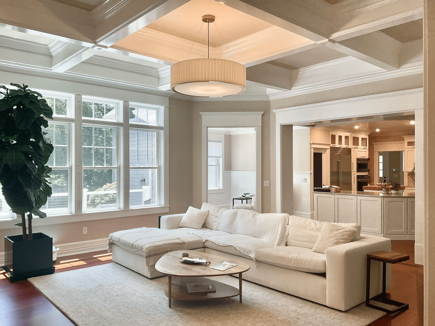 A bright, open, freshly renovated living room with white walls and large windows