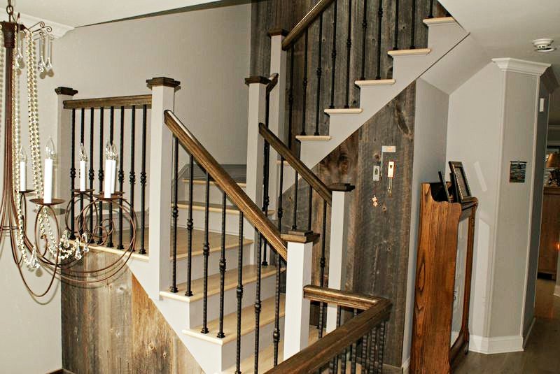 A rebuilt staircase with modern metal balusters below a chandelier